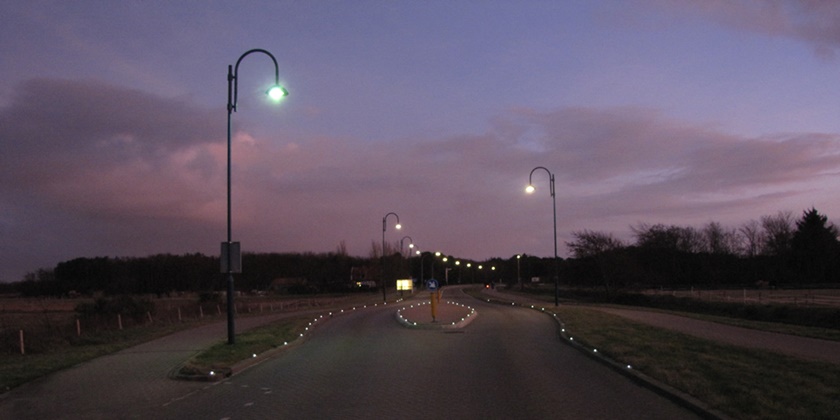 Lantaarnpalen verlichten een weg tijdens de schemering
