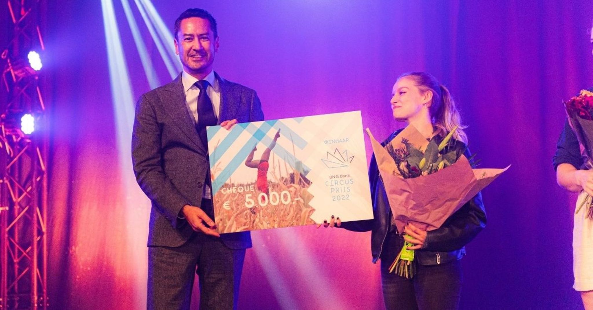 Harald Bergmann overhandigt symbolisch een cheque van €5.000 aan een paar roze kaplaarzen namens winnaar Harvey Cobb tijdens Festival Circolo.