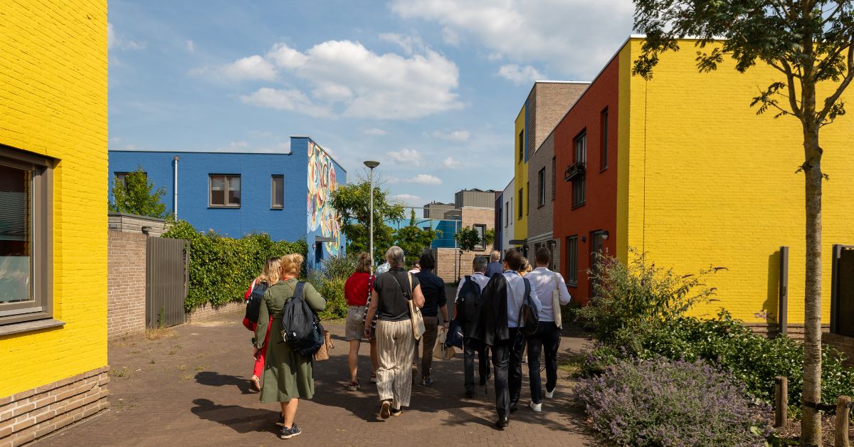 Een groep mensen op excursie in de woonwijk Woensel-West tijdens het VNG-congres. 