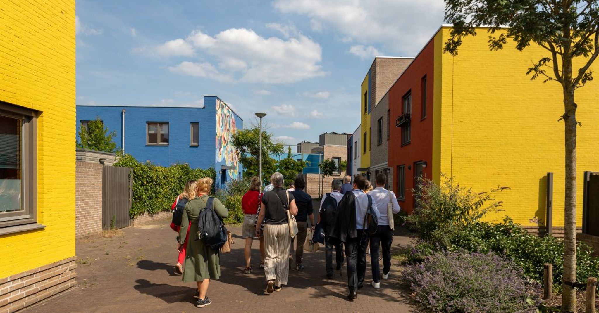 Een groep mensen op excursie in de woonwijk Woensel-West tijdens het VNG-congres.