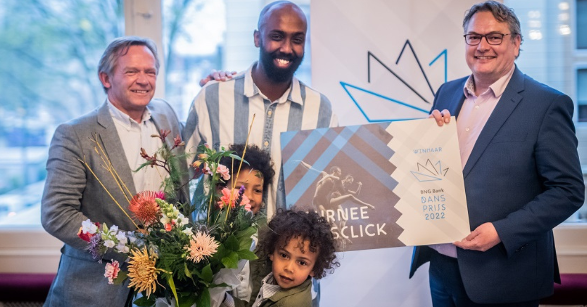 Winnaar van de BNG Dansprijs 2022 Mohamed Yusuf Boss op het podium met zijn cheque en een bos bloemen.