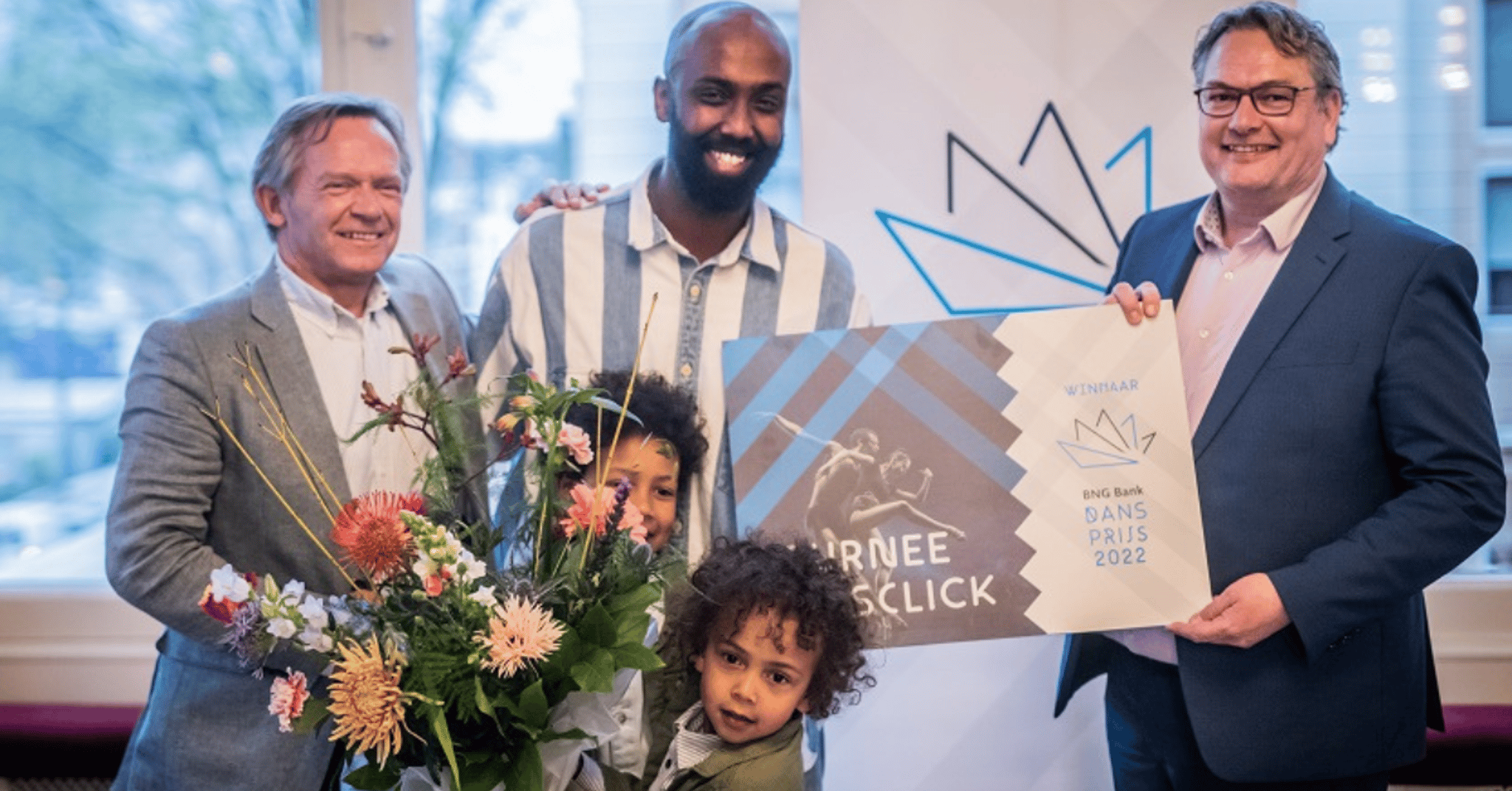 Winnaar van de BNG Dansprijs 2022 Mohamed Yusuf Boss op het podium met zijn cheque en een bos bloemen.