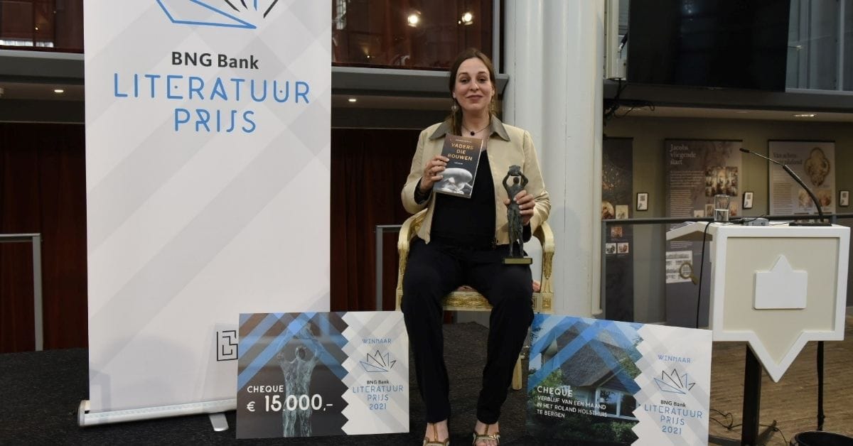 Carmien Michels poseert op de foto met de BNG Bank Literatuurprijs 2022 in de Amstelkerk Amsterdam.