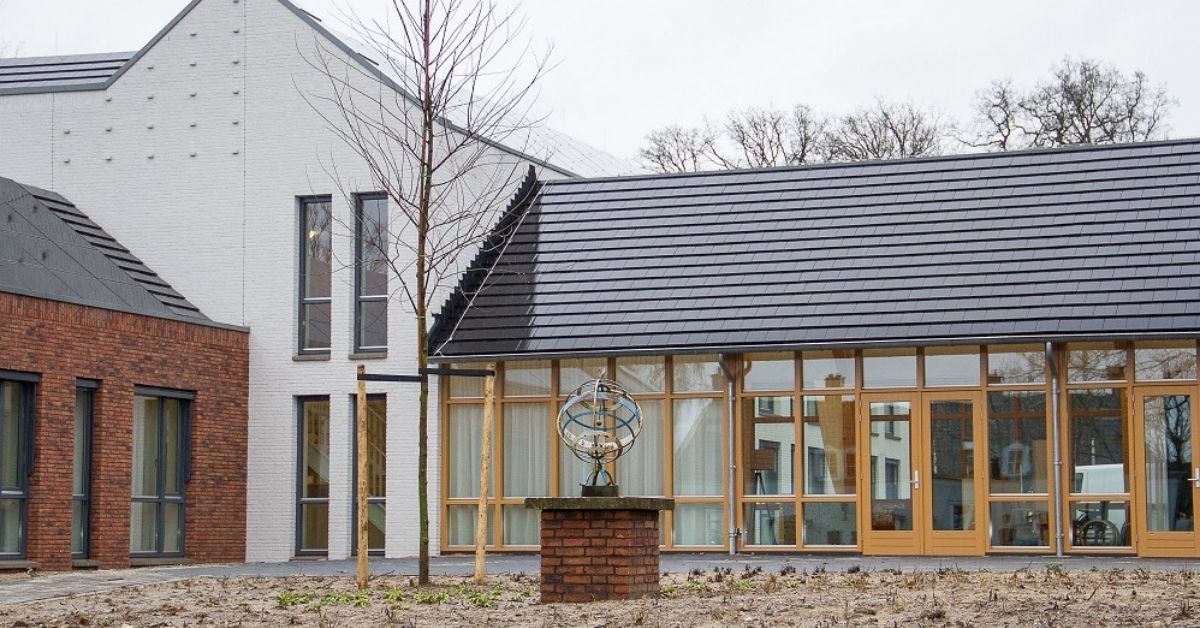 Een nieuw, kleinschalig woonzorgcentrum met een witte gevel met veel glas.