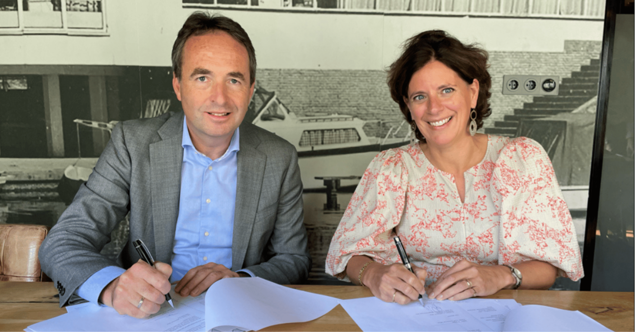 Een man en een vrouw tekenen een overeenkomst.