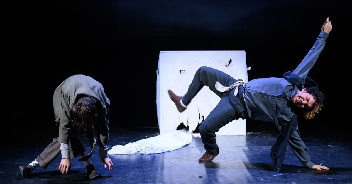 Twee mannen voeren een circusact op het podium uit.